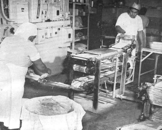 Del cortador, las tortillas pasan por tres hornos de gas, donde se cuecen. La instalación completa se muestra en esta foto. Ab: Una vez frías, las tortillas se envuelven cuidadosamente en papel encerado para su entrega