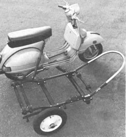 El sub-bastidor para un sidecar Vespa se fija con pernos a la motoneta, en vez de soldarse (izquierda). Luego el sidecar se fija con pernos al bastidor. Note la gaza de acero en la parte delantera, a fin de proteger contra impactos.