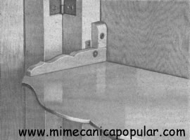 Los topes a cada lado sostienen en ángulo recto el anaquel caedizo.