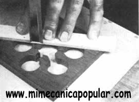 Se cortan los espacios entre los agujeros de una un octavo de pulgada, usándose para hacerlo un escoplo afilado que se guía con una regla