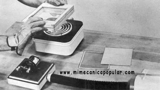 2. La lámina plástica, arriba, se calienta por ambos lados sobre una hormilla para darle plasticidad. Luego, el soporte y la lámina se colocan sobre el modelo en la caja al vacío. La presión del aire, abajo, fuerza al plástico a hacer contacto con el modelo