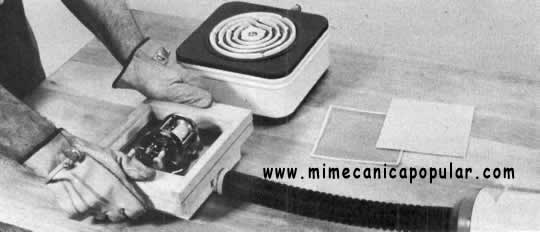 2. La lámina plástica, arriba, se calienta por ambos lados sobre una hormilla para darle plasticidad. Luego, el soporte y la lámina se colocan sobre el modelo en la caja al vacío. La presión del aire, abajo, fuerza al plástico a hacer contacto con el modelo