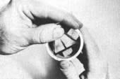 Deslice los espejos dentro del tubo de manera que formen un tri&aacute;ngulo, le cara del espejo mirando hacia adentro. Les tres tires de madera que sostienen los espejos en su lugar deben caber apretados, pero usted debe tener cuidado de no ara&ntilde;ar ninguno de los reversos de los espejos seg&uacute;n los va colocando en la madera